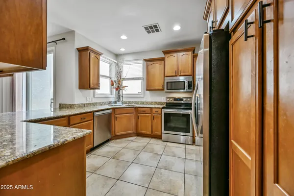a kitchen with granite countertop a stove top oven microwave and cabinets
