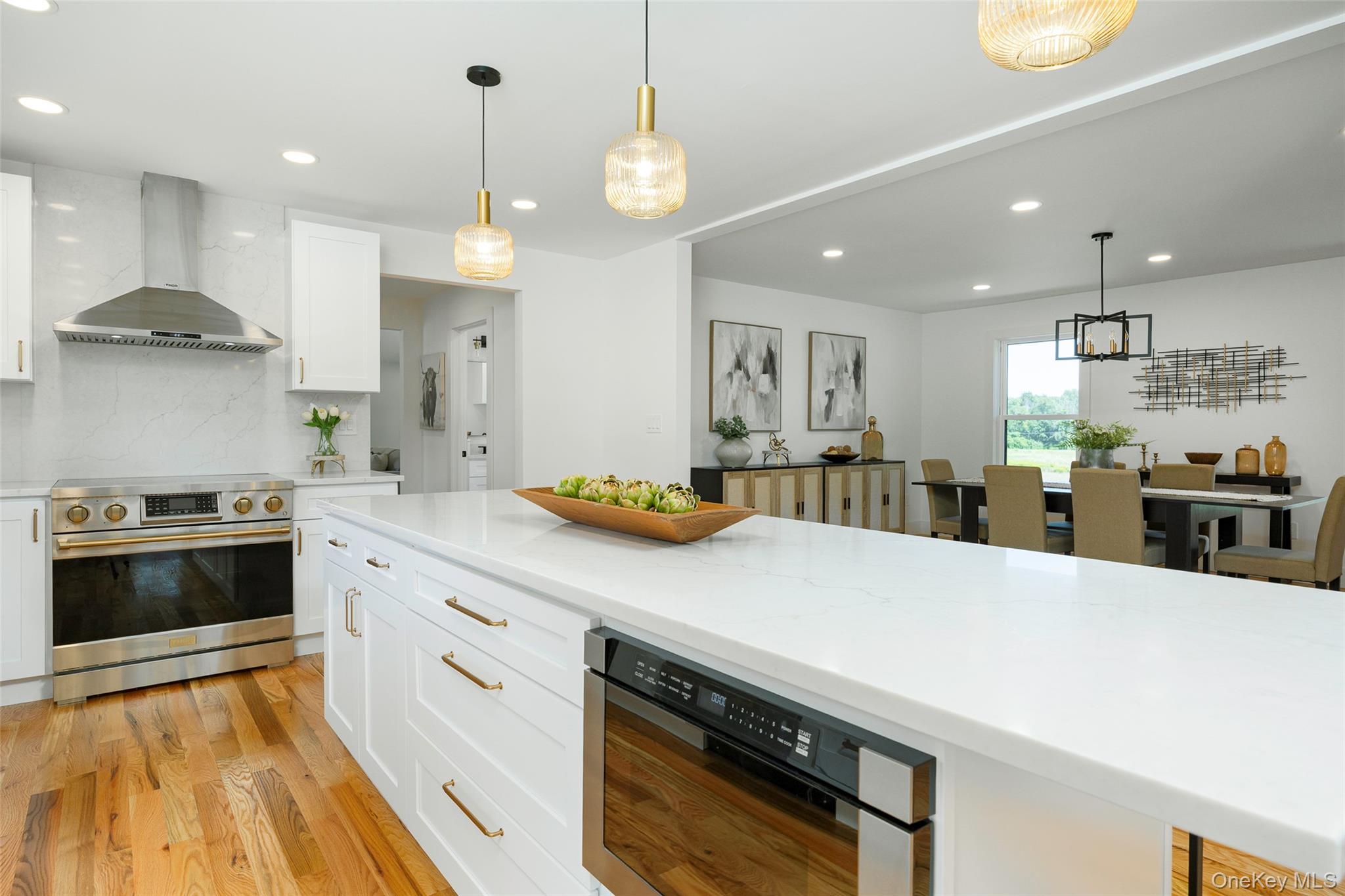 327 Hynes Road Poughquag, NY 12570 - Photo 9 of 39 Kitchen featuring stainless steel appliances, white cabinetry, wall chimney range hood, decorative light fixtures, and tasteful backsplash