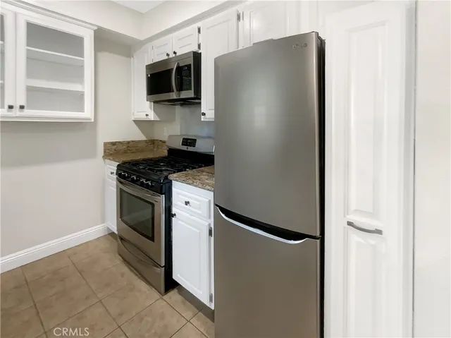 a kitchen with granite countertop a sink stove and cabinets