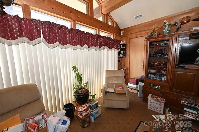 a view of a dining room with furniture a chandelier and large windows