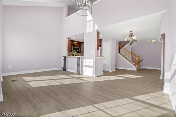 a view of a livingroom with wooden floor and a ceiling fan