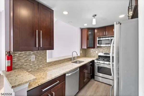 a kitchen with kitchen island granite countertop stainless steel appliances and sink