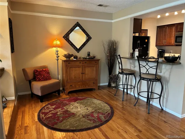 a living room with furniture and a wooden floor