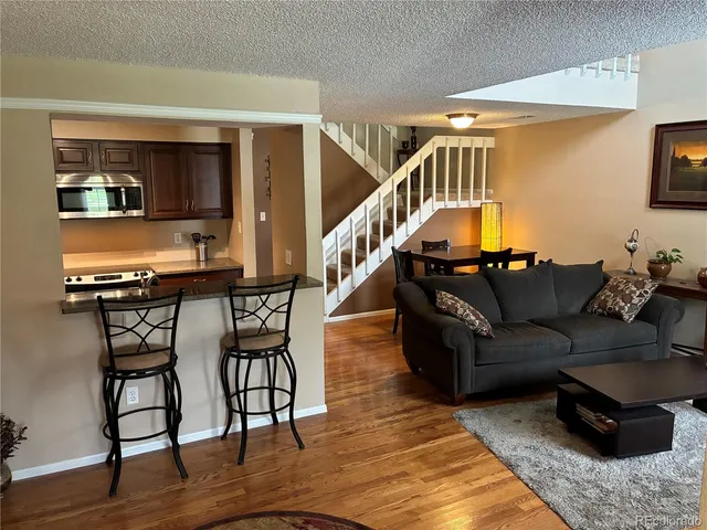 a living room with furniture and a kitchen view