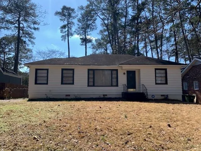 a front view of a house with a yard covered with snow