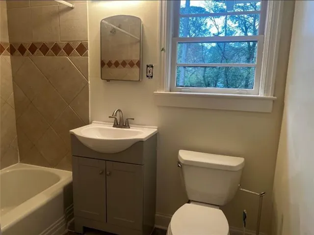 a bathroom with a toilet a sink and tub