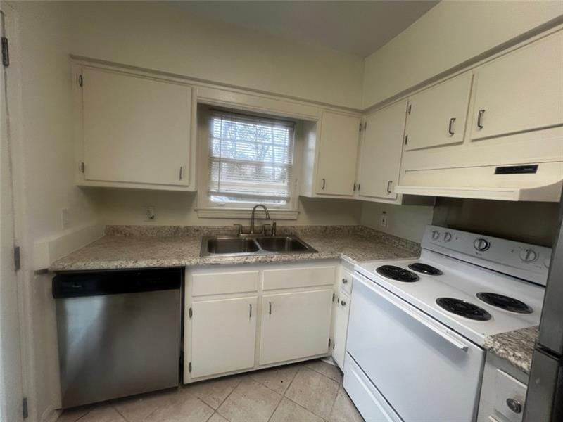 977 Lindridge Way Northeast Atlanta, GA 30324 - Photo 17 of 18 a kitchen with cabinets appliances a sink and a window