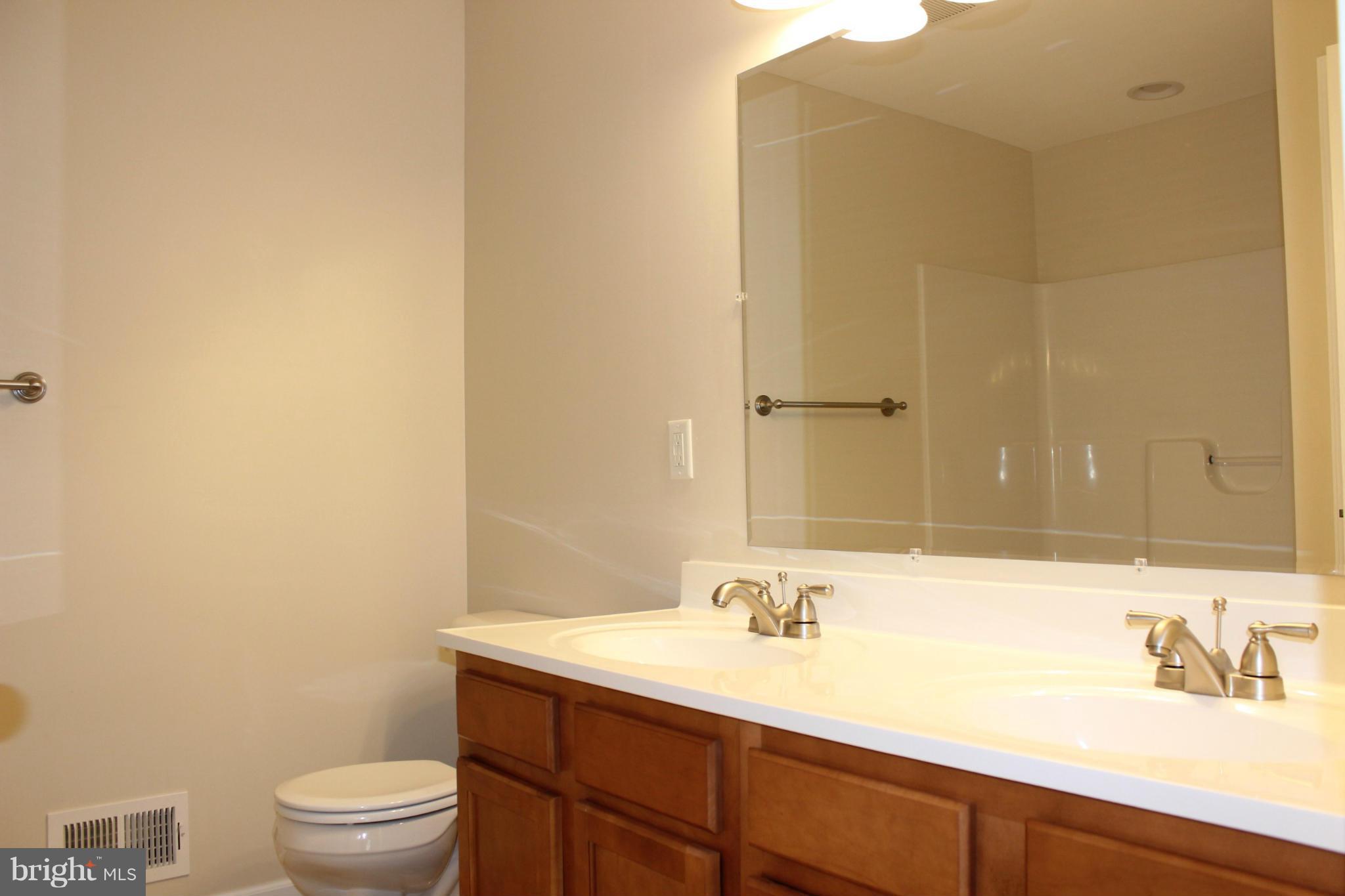 321 East 3rd Avenue Ranson, WV 25438 - Photo 13 of 15 a bathroom with a sink a toilet and a mirror