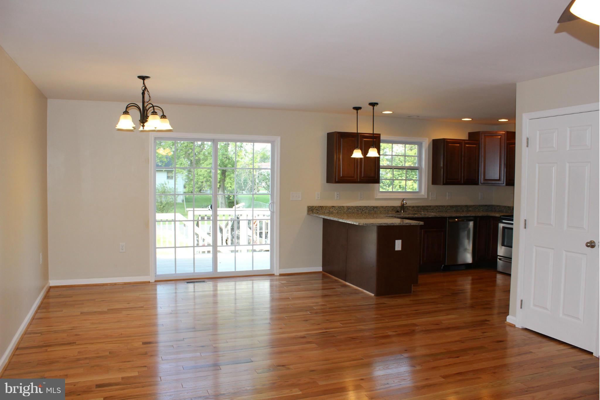 321 East 3rd Avenue Ranson, WV 25438 - Photo 6 of 15 a kitchen with kitchen island granite countertop a stove and a wooden floor