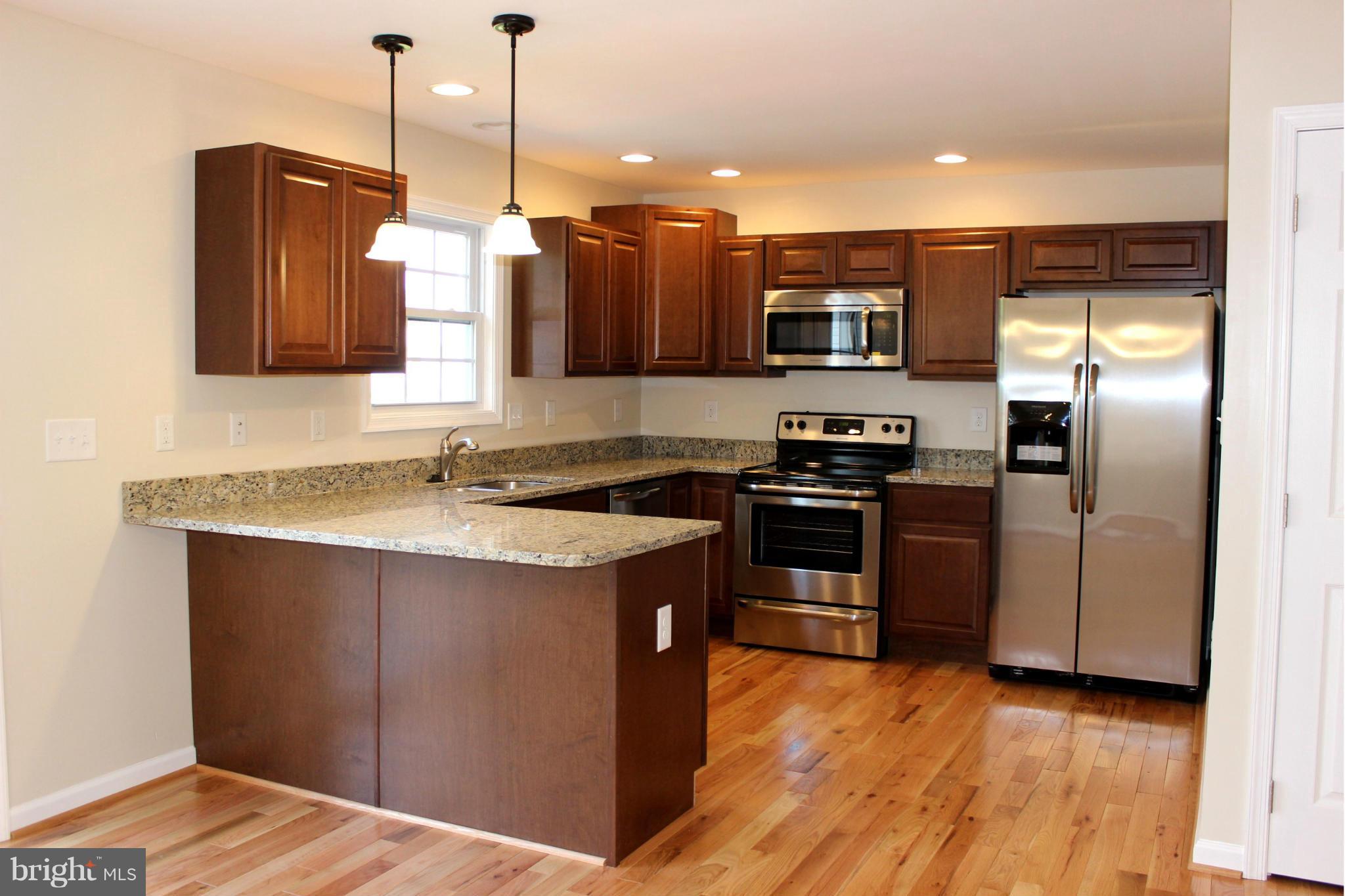 321 East 3rd Avenue Ranson, WV 25438 - Photo 8 of 15 a kitchen with stainless steel appliances granite countertop a sink a stove and a refrigerator