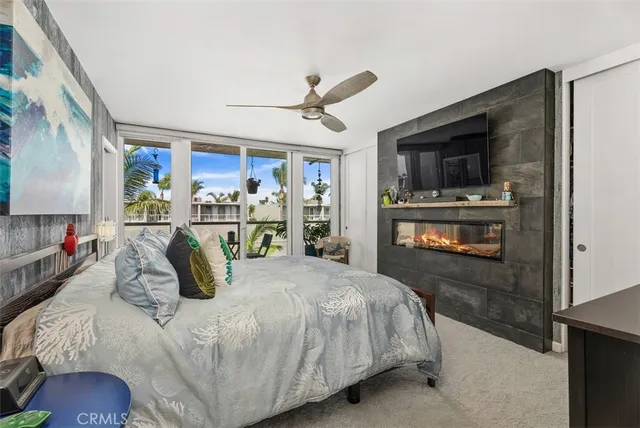 a bedroom with a bed a flat screen tv and a fireplace