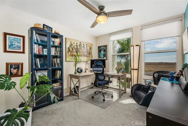 a view of a livingroom with workspace and a window