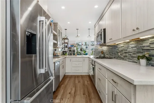 a kitchen with stainless steel appliances a refrigerator sink and white cabinets