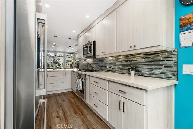 a kitchen with cabinets appliances a sink and a window