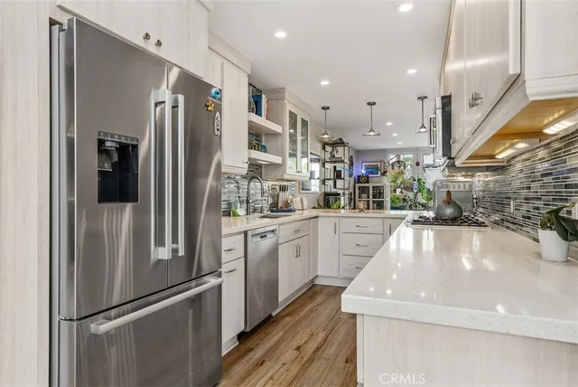 a kitchen with stainless steel appliances granite countertop a refrigerator and a sink