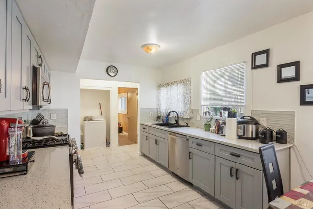 a kitchen with stainless steel appliances a sink stove and cabinets