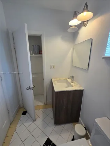 a bathroom with a sink vanity and toilet