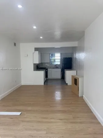 a view of a kitchen with a sink and a refrigerator