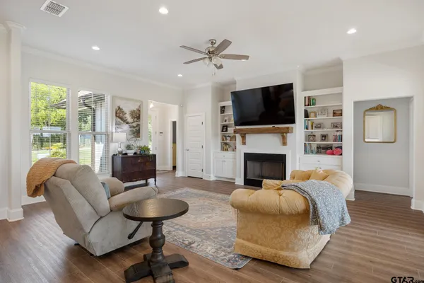 a large kitchen with stainless steel appliances kitchen island a refrigerator a stove a sink and a dining table with wooden floor