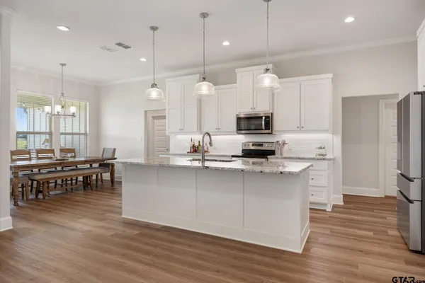 a kitchen with white cabinets and stainless steel appliances