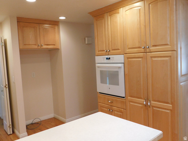 2148 Carolyn Way Bountiful, UT 84010 - Photo 5 of 40 Kitchen featuring light wood cabinetry with crown molding, a built-in wall oven, recessed lighting, and wood-finish flooring