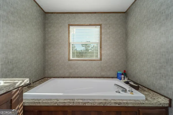 a bathroom with a granite countertop bathtub and window