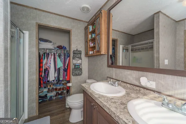a bathroom with a granite countertop sink a toilet and a mirror