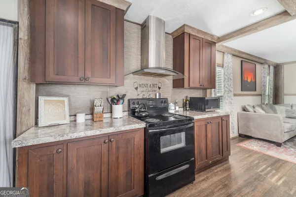 a kitchen with stainless steel appliances granite countertop a stove a sink dishwasher and cabinets with wooden floor