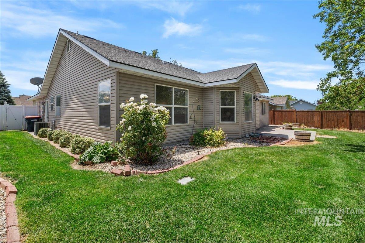 2032 Talus Loop Twin Falls, ID 83301 - Photo 43 of 43 Expansive backyard featuring a manicured lawn, a large concrete patio, and a privacy fence