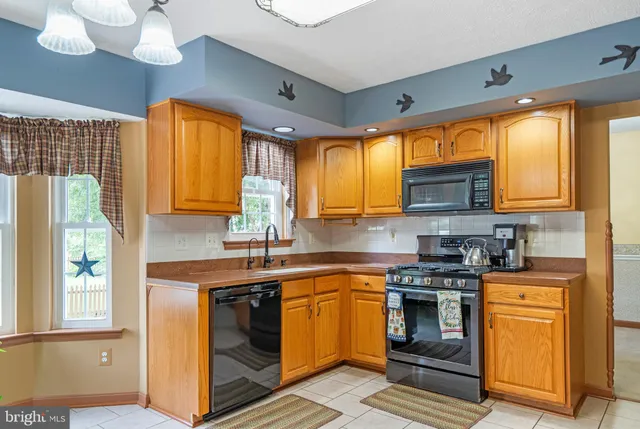 a kitchen with stainless steel appliances granite countertop a sink a stove cabinets and a counter top space
