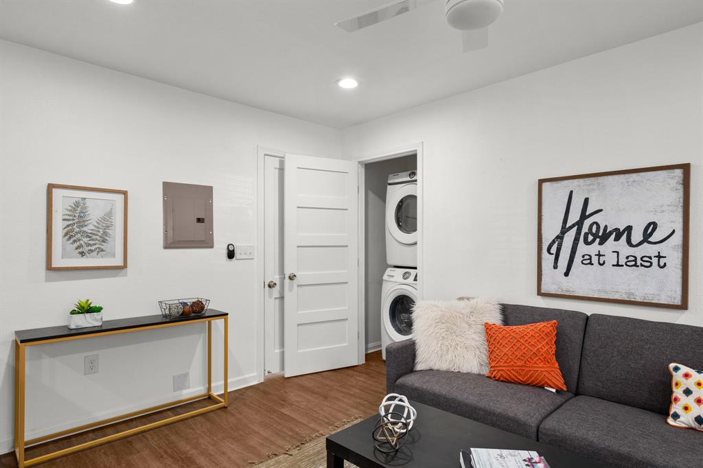 301 East 33rd Street, Unit 4 Austin, TX 78705 - Photo 4 of 10 Living area featuring electric panel, stacked washer / drying machine, wood finished floors, and recessed lighting