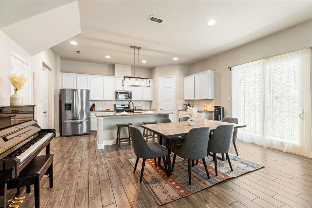620 Ansley Way Allen, TX 75013 - Photo 9 of 31 a kitchen with stainless steel appliances a dining table chairs stove refrigerator and cabinets