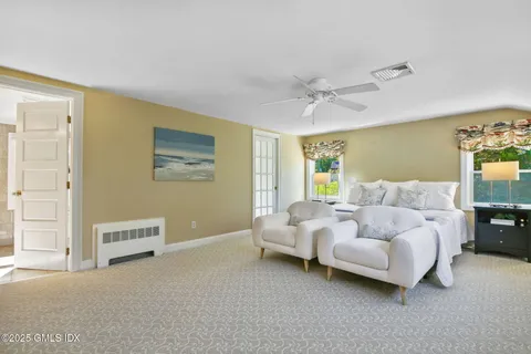 a spacious bedroom with a bed and a lamp