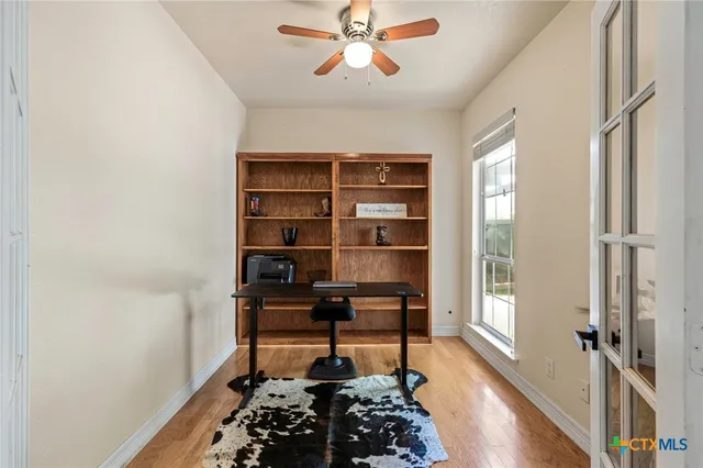 a kitchen with stainless steel appliances kitchen island granite countertop a dining table chairs and a refrigerator