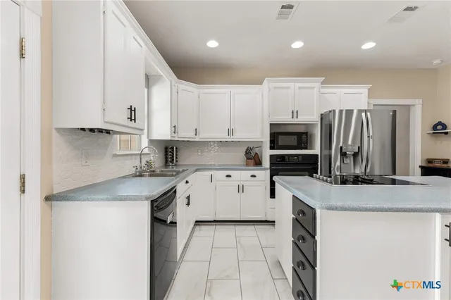 a kitchen with stainless steel appliances granite countertop a refrigerator and a sink