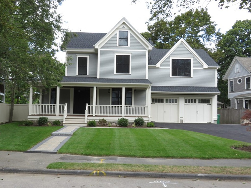 a front view of a house with a yard and trees