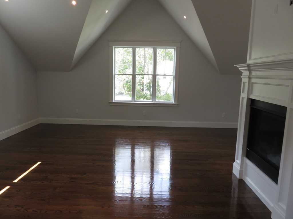 12 Maple Street Newton, MA 02466 - Photo 8 of 28 an empty room with wooden floor fireplace and windows
