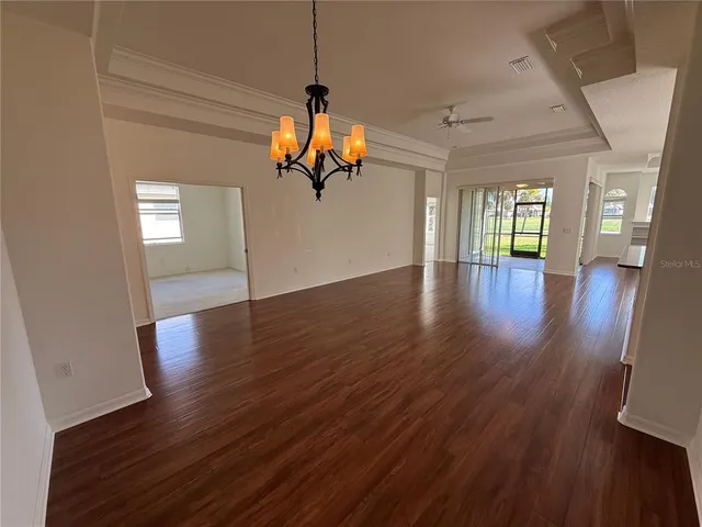 a view of a room with wooden floors and ceiling fan