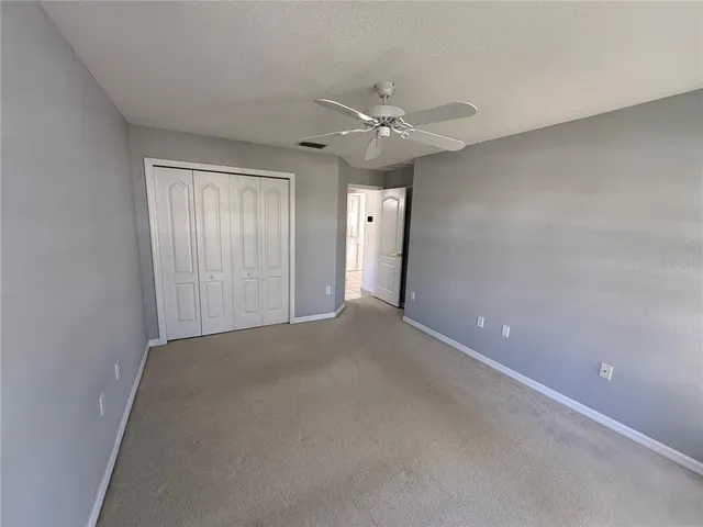 an empty room with a ceiling fan and a window