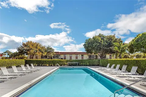 a view of a house with pool and chairs