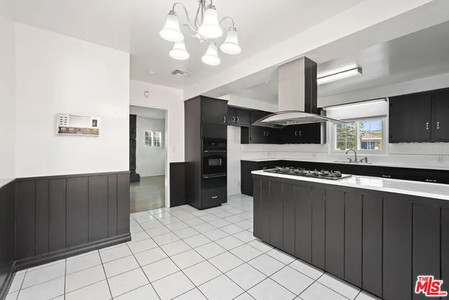 a kitchen with stainless steel appliances a refrigerator and a stove top oven