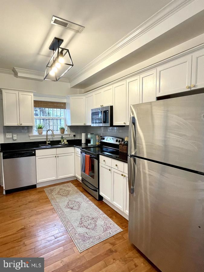 1656 Kramer Street Northeast Washington, DC 20002 - Photo 11 of 29 a kitchen with granite countertop a refrigerator a stove top oven a sink a counter space and cabinets