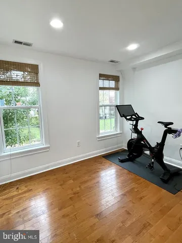 a view of room with wooden floor and gym equipment