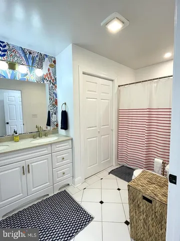 a spacious bathroom with a granite countertop sink a mirror and shower