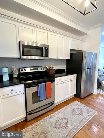 a kitchen with stainless steel appliances granite countertop a refrigerator stove a sink and a microwave