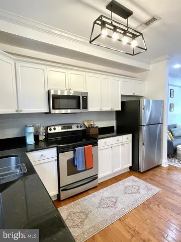 a kitchen with a refrigerator and a stove top oven