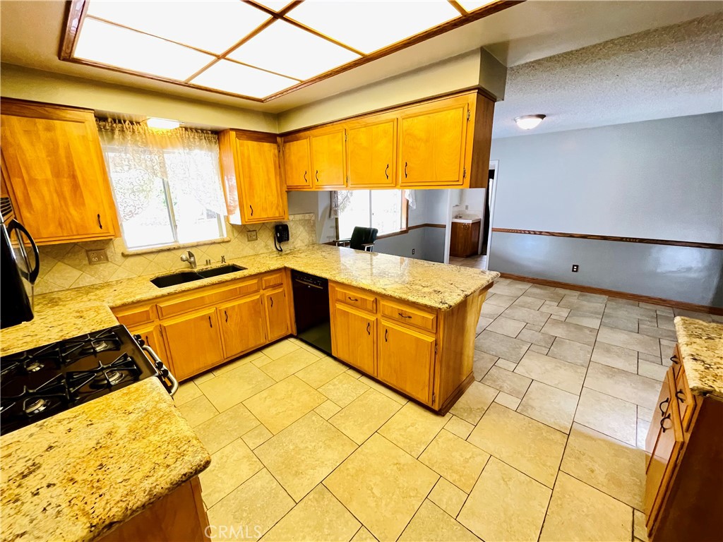 5875 Olive Avenue Rialto, CA 92377 - Photo 25 of 54 a kitchen with stainless steel appliances granite countertop a sink and a stove