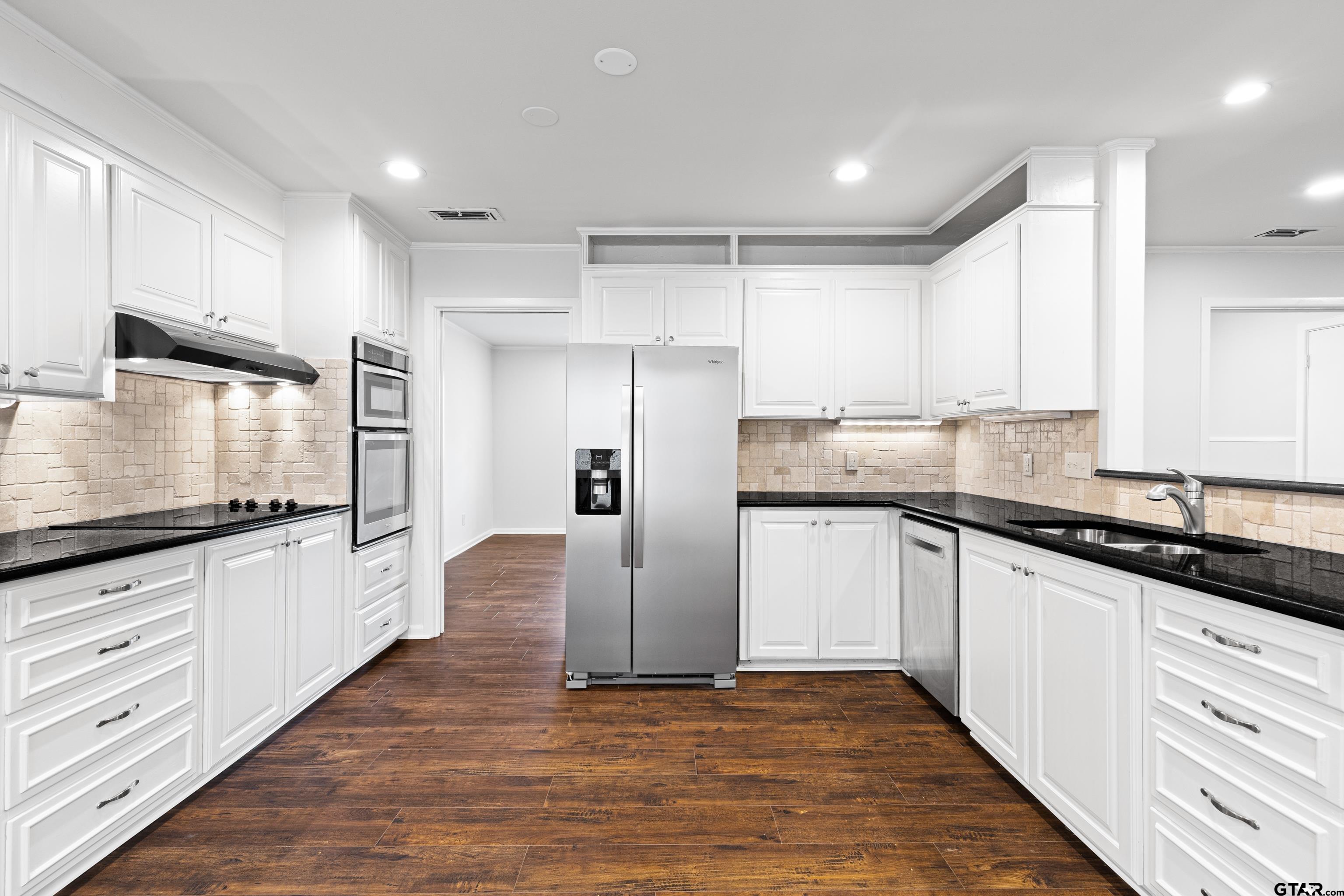 7 Lindsey Lane Longview, TX 75601 - Photo 13 of 36 a kitchen with granite countertop white cabinets and white appliances