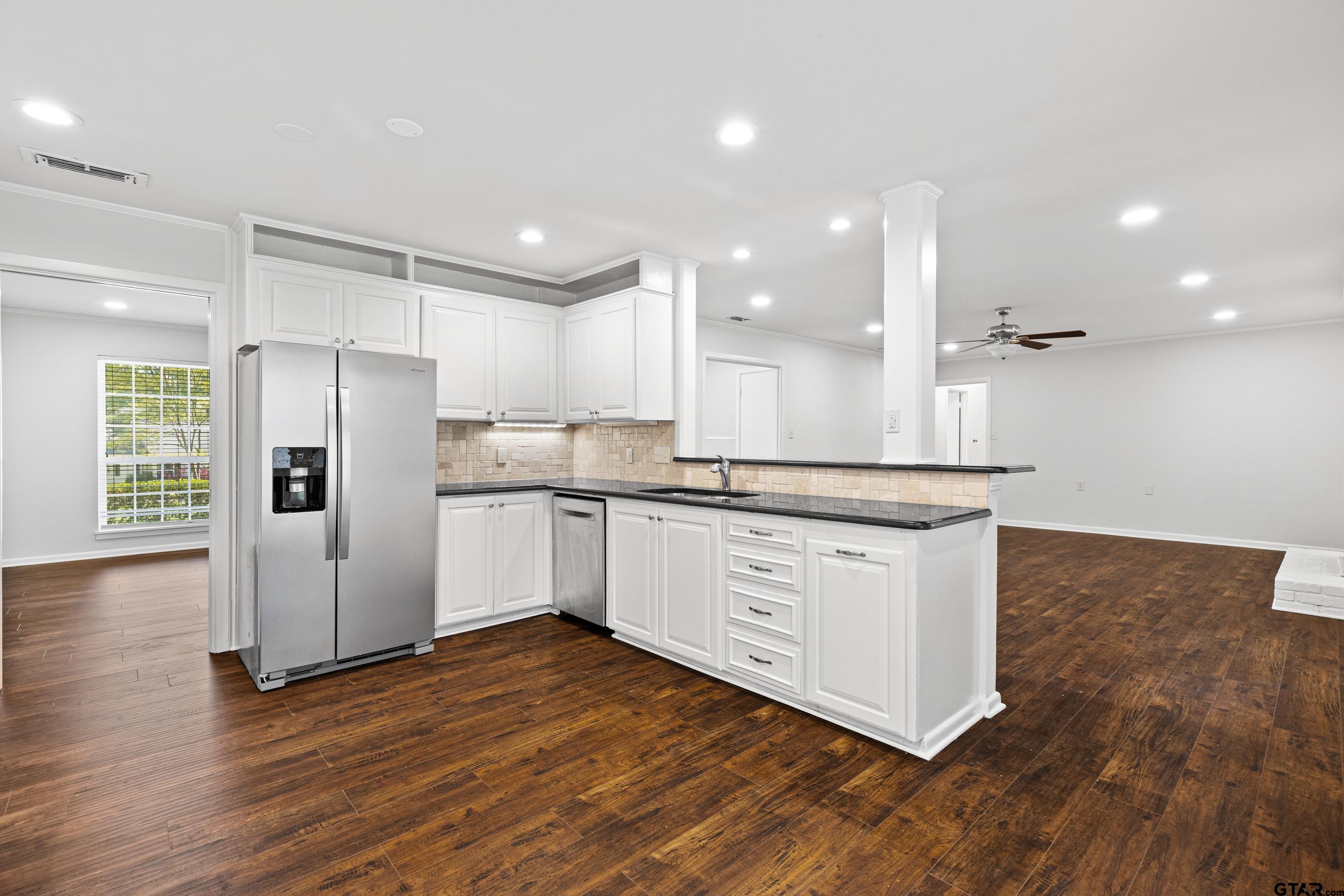 7 Lindsey Lane Longview, TX 75601 - Photo 14 of 36 a kitchen with stainless steel appliances granite countertop a refrigerator a sink a stove and white cabinets with wooden floor