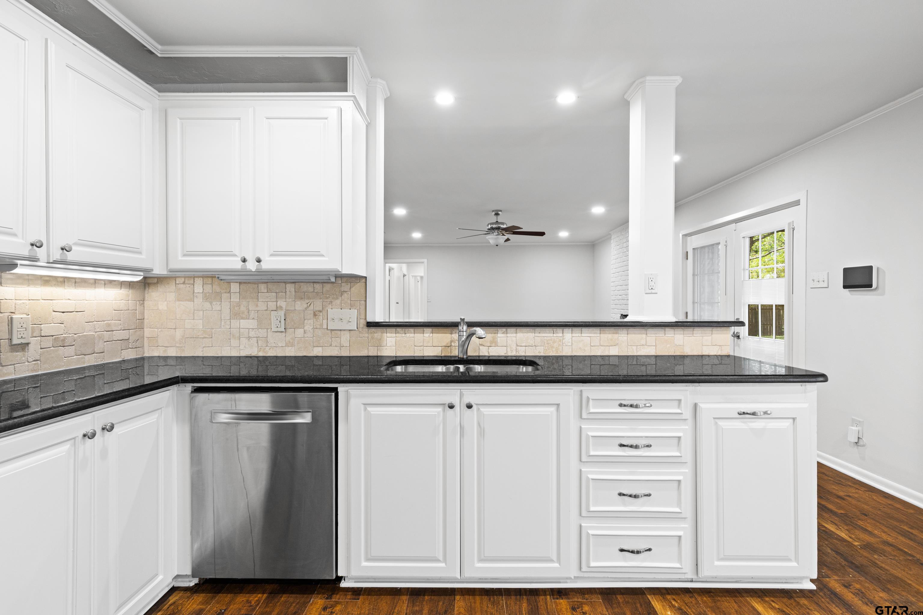 7 Lindsey Lane Longview, TX 75601 - Photo 15 of 36 a kitchen with granite countertop a sink cabinets and wooden floor